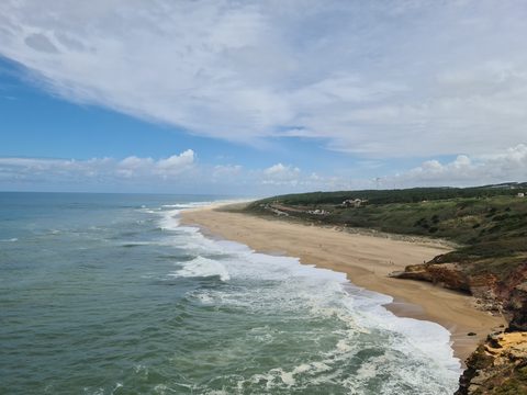An elevated view of Praia do Norte's long sandy beach and headland